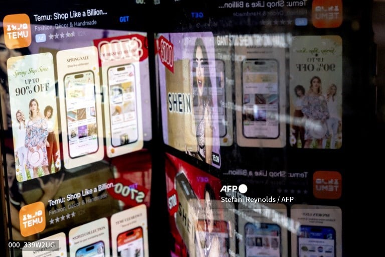 LOOK: This photo illustration shows the Temu app in the App Store reflected in videos of Shein consumers, in Washington, DC, on February 23, 2023. |  📷 Stefani Reynolds / AFP
